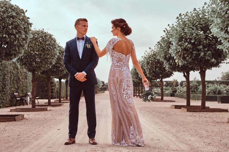 Full body portrait of newlyweds posing in the beautiful garden